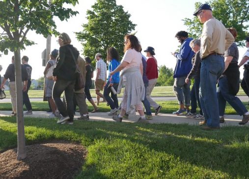 A group of people walking outside on a sunny day